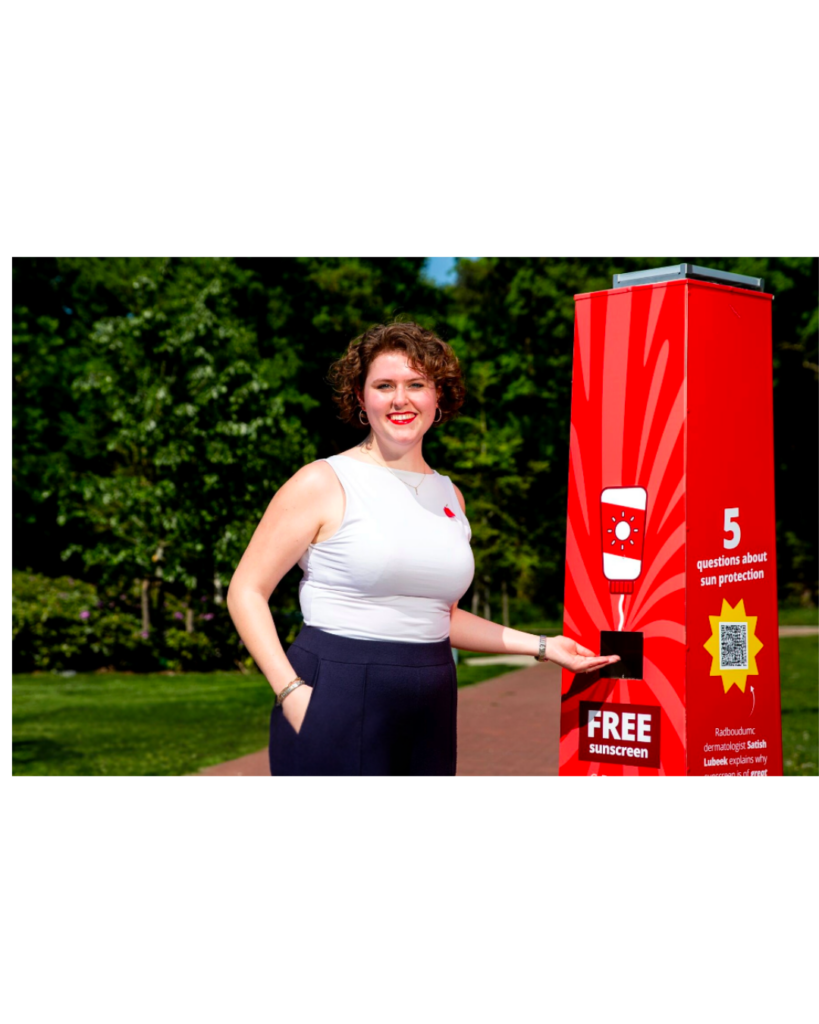 Een vrouw bij een rood zonnebrandcrème-station op de campus van de Radboud Universiteit Nijmegen
