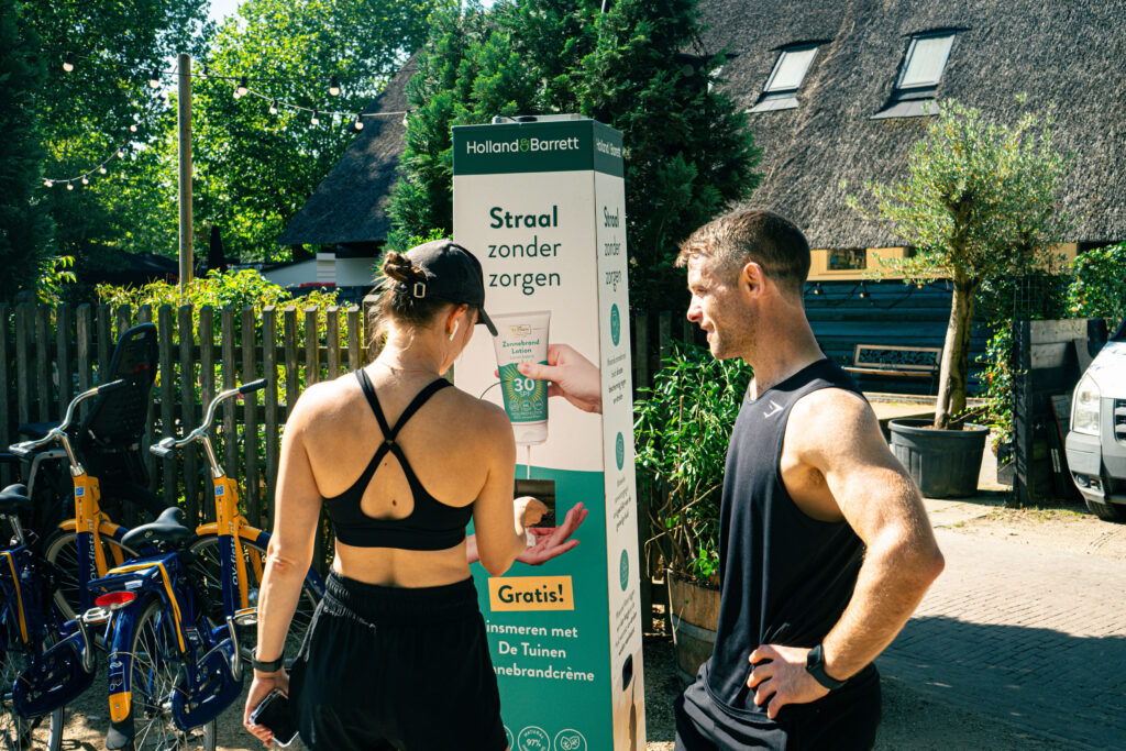 Hardlopers smeren zich in bij een Smeerkees zonnebrandpaal in samenwerking met Holland & Barrett.